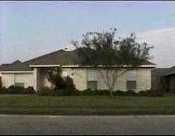 a view of a house with a yard and a large parking space