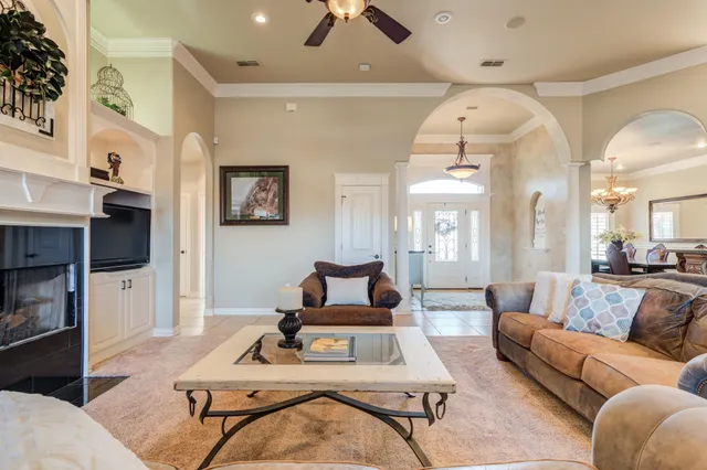 a living room with furniture kitchen view and a chandelier