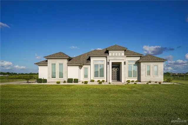 a front view of a house with a garden