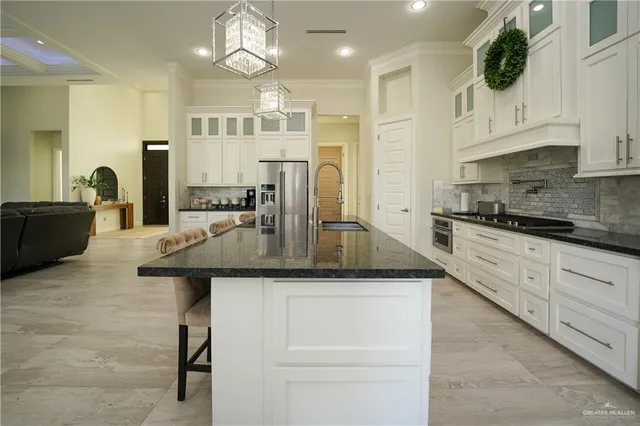 a kitchen with stainless steel appliances granite countertop a sink a stove and cabinets