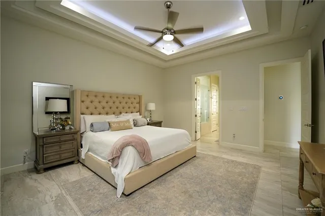 a spacious bedroom with a bed and a chandelier