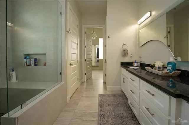a spacious bathroom with a granite countertop sink mirror and shower