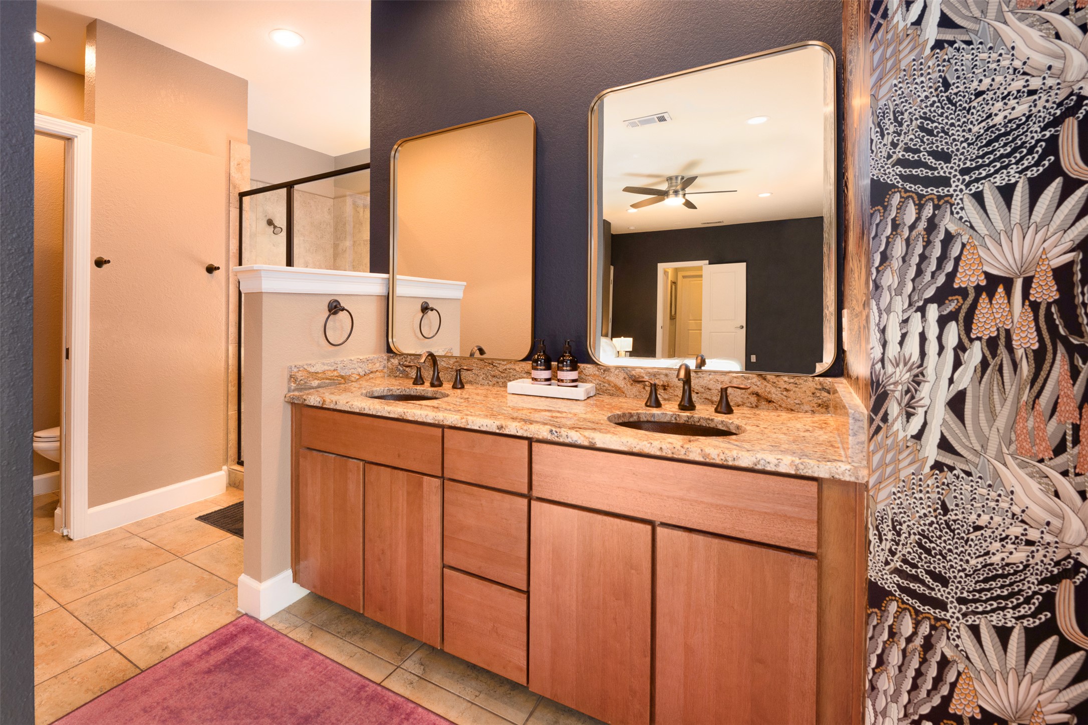 2302 East 9th Street Austin, TX 78702 - Photo 14 of 31 Double vanities with stone counters and a spacious walk-in shower elevate this contemporary bathroom.