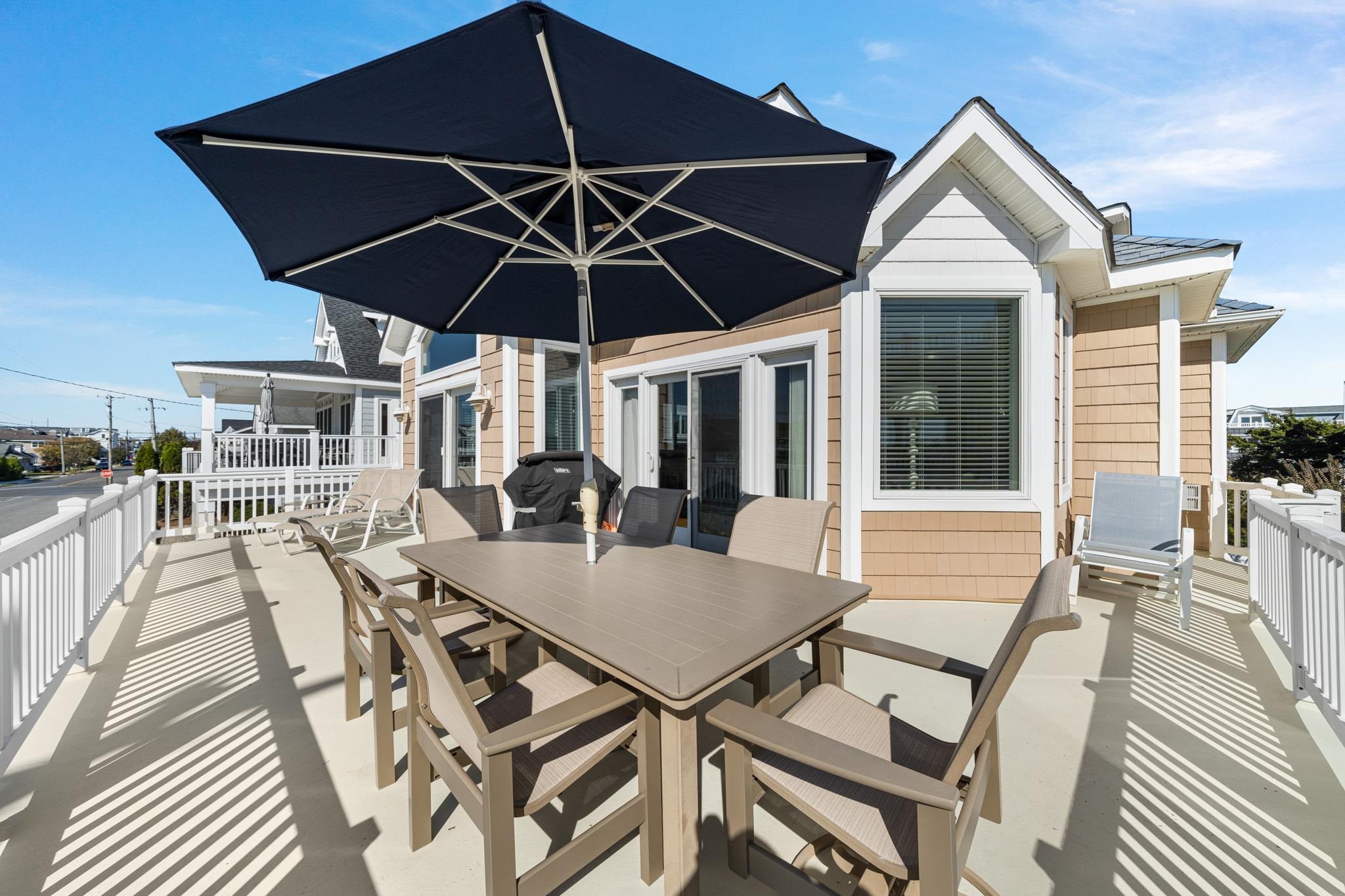 55 West 29th Avalon, NJ 08202 - Photo 7 of 32 a view of a patio with table and chairs under an umbrella
