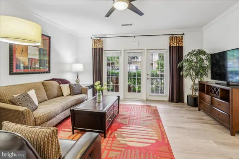 a living room with furniture a flat screen tv and a large window