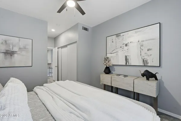 a bedroom with a bed and a painting on the wall