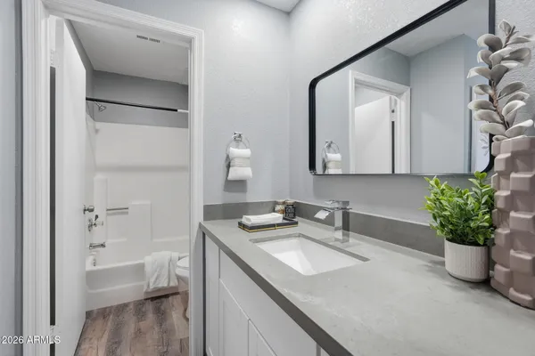 a bathroom with a granite countertop sink and a mirror