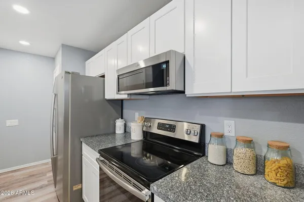 a kitchen with stainless steel appliances granite countertop a stove a microwave and cabinets