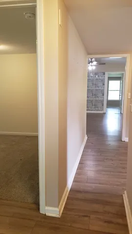a view of a hallway with wooden floor