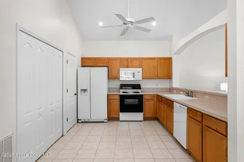 a large kitchen with stainless steel appliances granite countertop a refrigerator and a sink