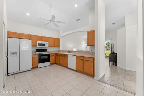a large kitchen with stainless steel appliances kitchen island granite countertop a refrigerator and a stove top oven