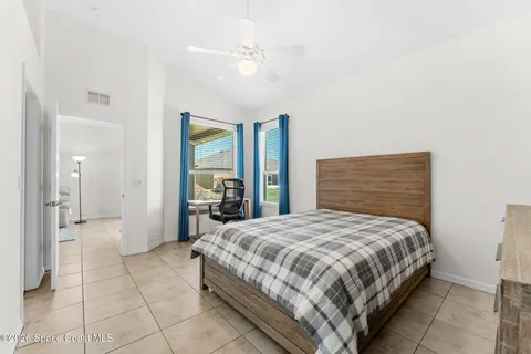 a bedroom with a bed a ceiling fan and a rug