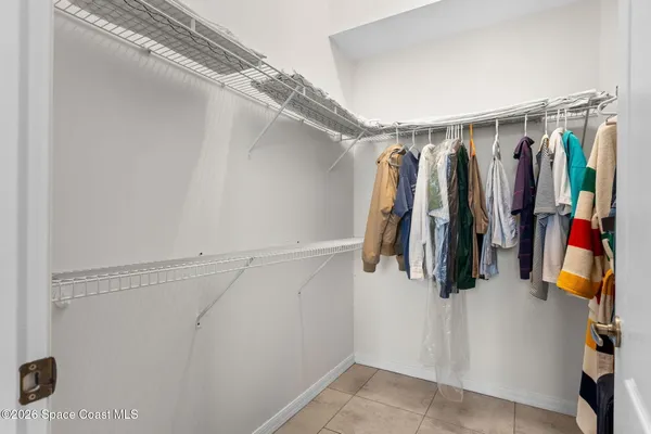 a view of walk in closet with clothes