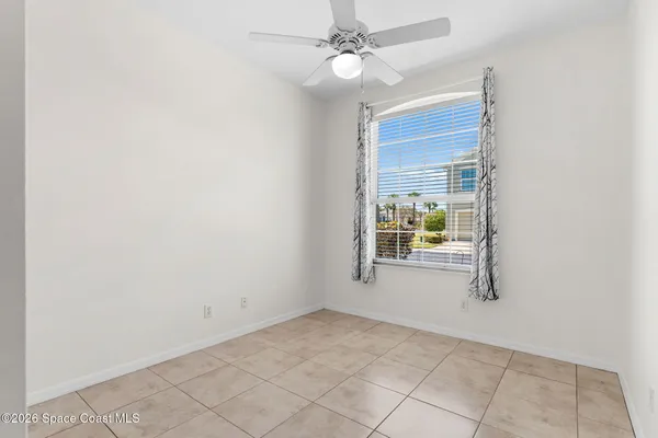 an empty room with windows and fan