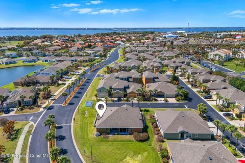 an aerial view of residential houses with outdoor space and ocean