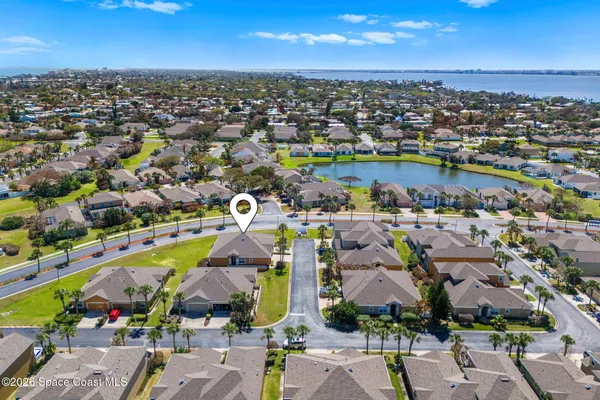 an aerial view of a city with lots of residential buildings ocean and mountain view in back