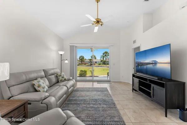 a living room with furniture a chandelier and a rug