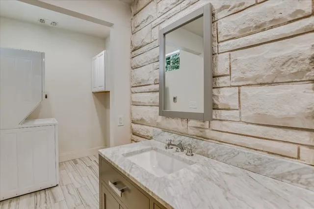 a bathroom with a granite countertop sink and a mirror