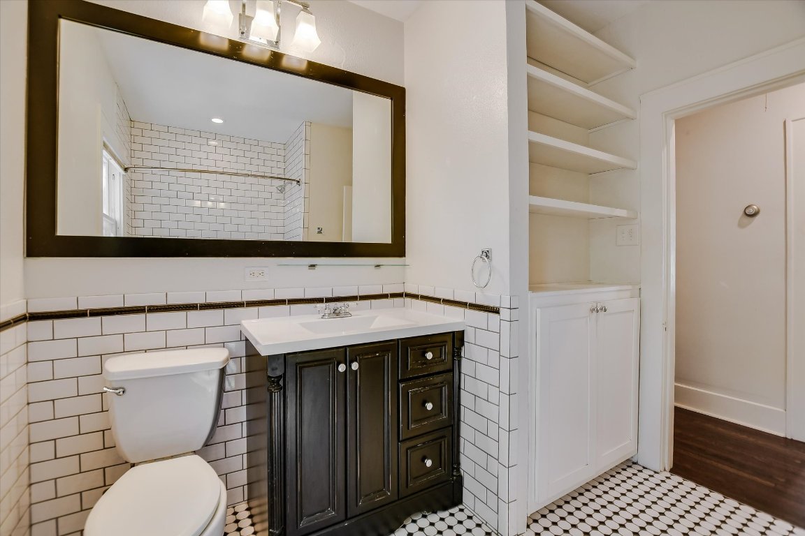 1007 Reagan Terrace Austin, TX 78704 - Photo 18 of 20 Secondary bathroom featuring tile walls, tile patterned floors, and vanity
