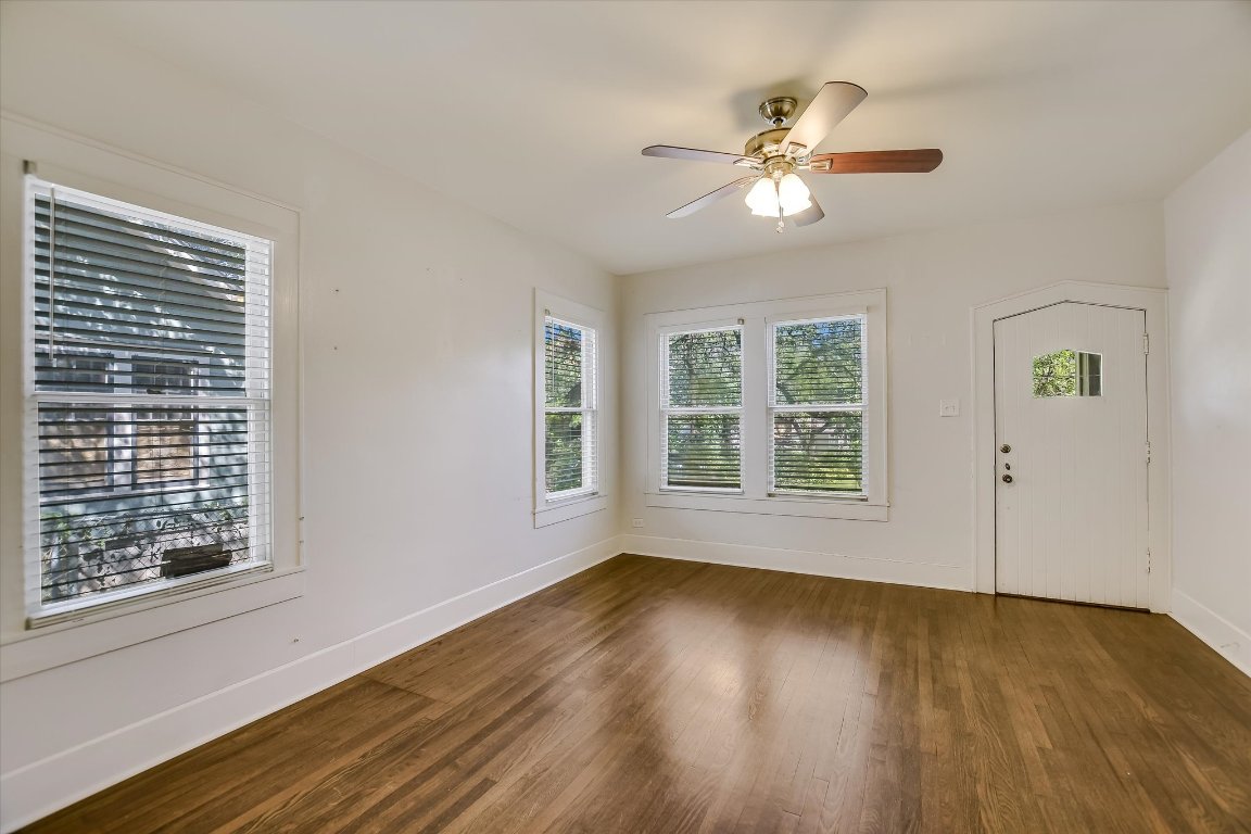 1007 Reagan Terrace Austin, TX 78704 - Photo 4 of 20 Front entry door to living area with baseboards, dark wood finished floors, and ceiling fan