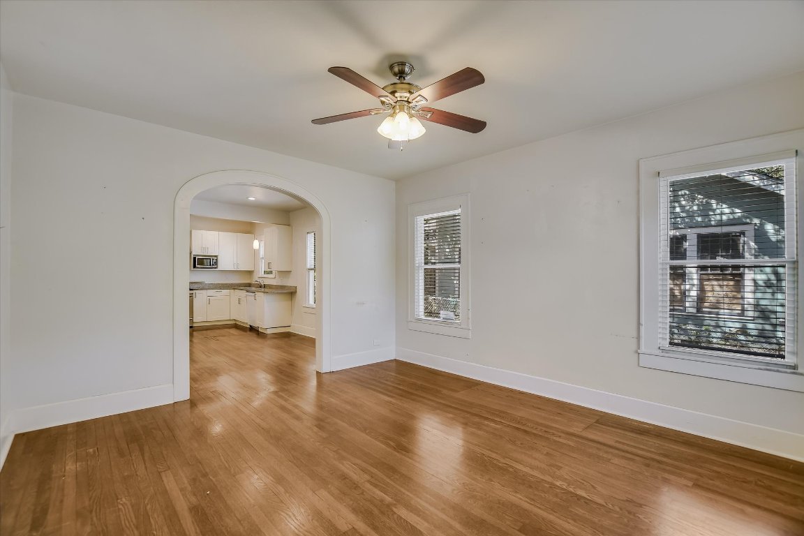 1007 Reagan Terrace Austin, TX 78704 - Photo 5 of 20 Living room with arched walkways, light wood-style flooring, and ceiling fan