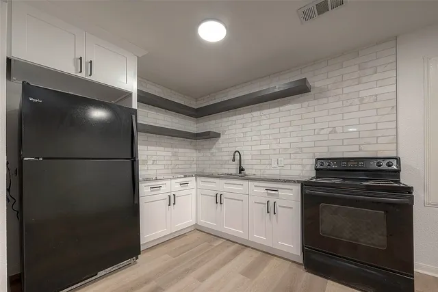 a kitchen with a stove and white cabinets