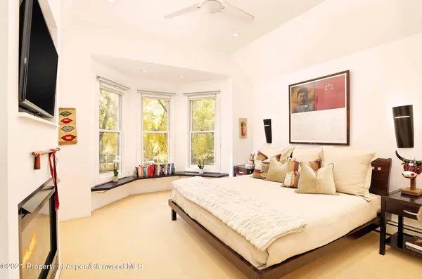 a bedroom with a bed window and a flat screen tv