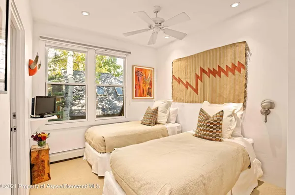 a bedroom with two beds and a large window