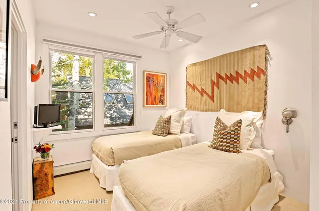 a bedroom with two beds and a large window