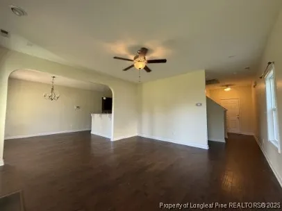 a view of an empty room with a ceiling fan and window