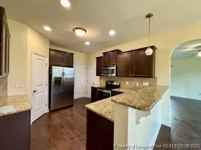 a kitchen with kitchen island granite countertop stainless steel appliances a refrigerator microwave and sink