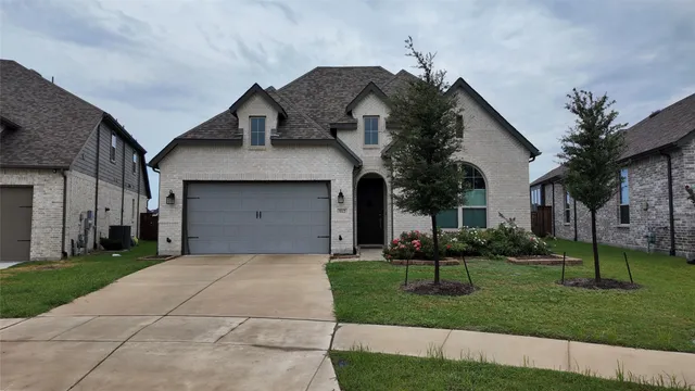 a front view of a house with a garden and plants