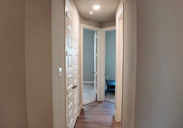 a view of a hallway with wooden floor