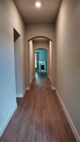 a view of a hallway with wooden floor and a fireplace