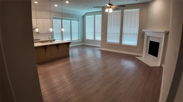 a view of a kitchen with granite countertop kitchen island wooden floors and stainless steel appliances