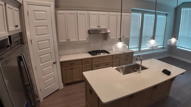 a kitchen with stainless steel appliances granite countertop a sink a refrigerator and a stove