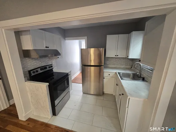 an empty room with wooden floor and window