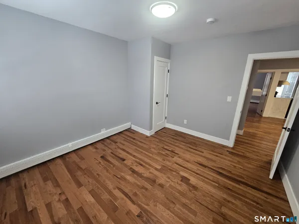 a view of empty room with wooden floor