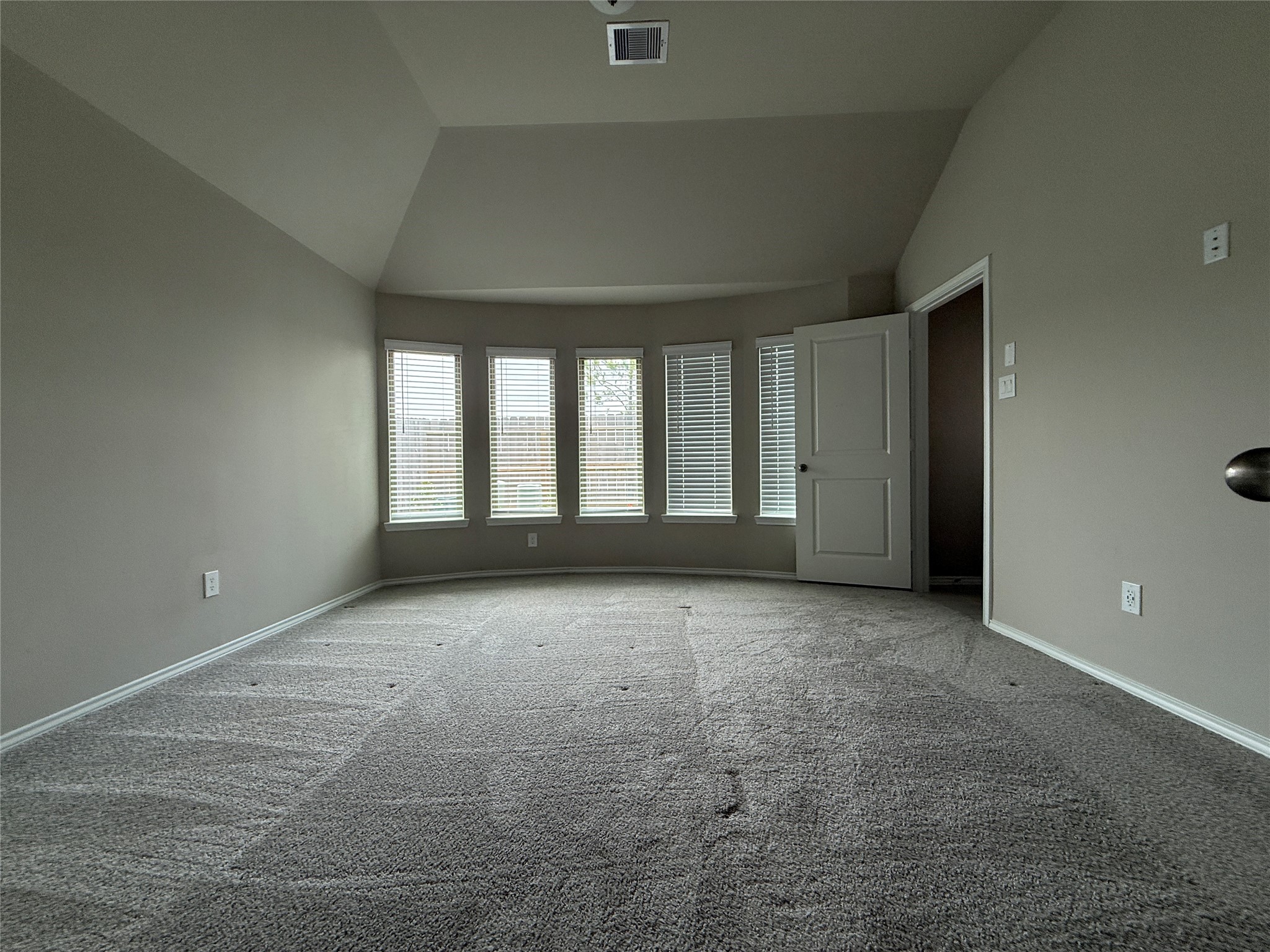 31961 Retama Rnch Drive Spring, TX 77386 - Photo 23 of 25 This room features a spacious layout with a large bay window for natural light, neutral-colored walls, and carpeted flooring. An open door leads to an adjacent space, adding to the room's functionality.