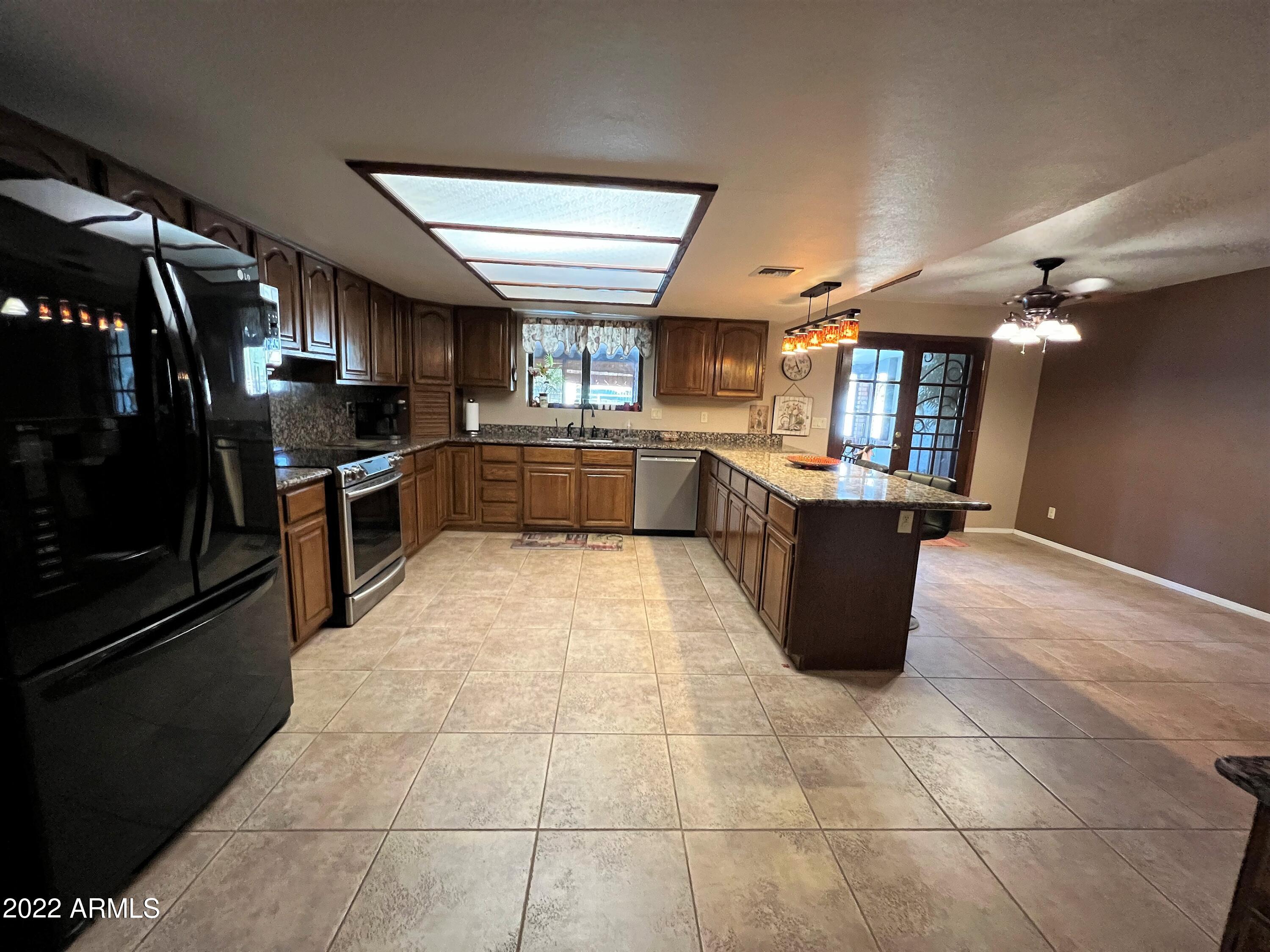 16502 West Magnolia Street Goodyear, AZ 85338 - Photo 16 of 59 a large kitchen with cabinets and stainless steel appliances
