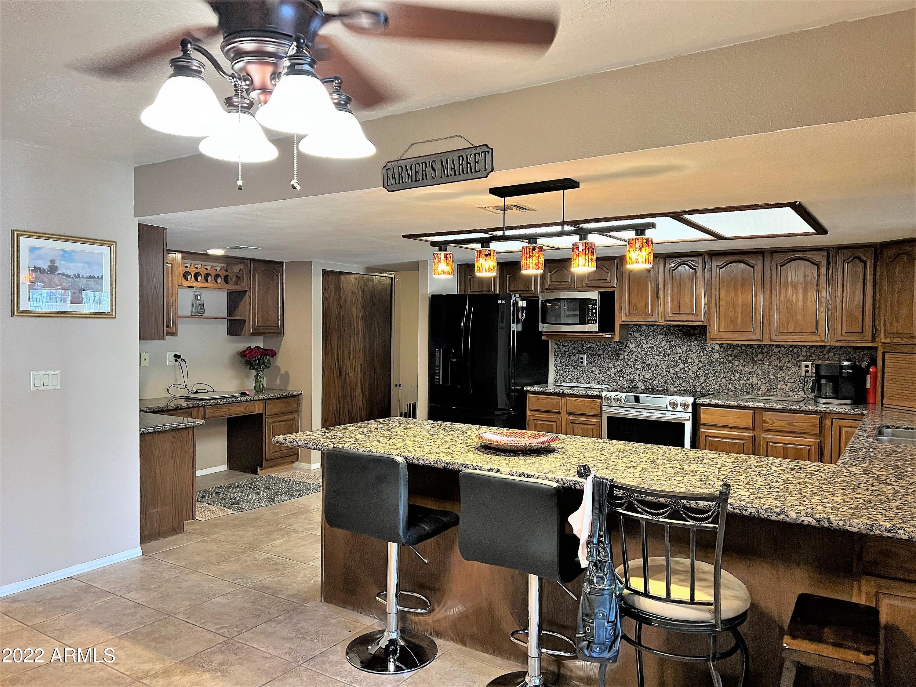 16502 West Magnolia Street Goodyear, AZ 85338 - Photo 17 of 59 a kitchen with a dining table chairs and white cabinets