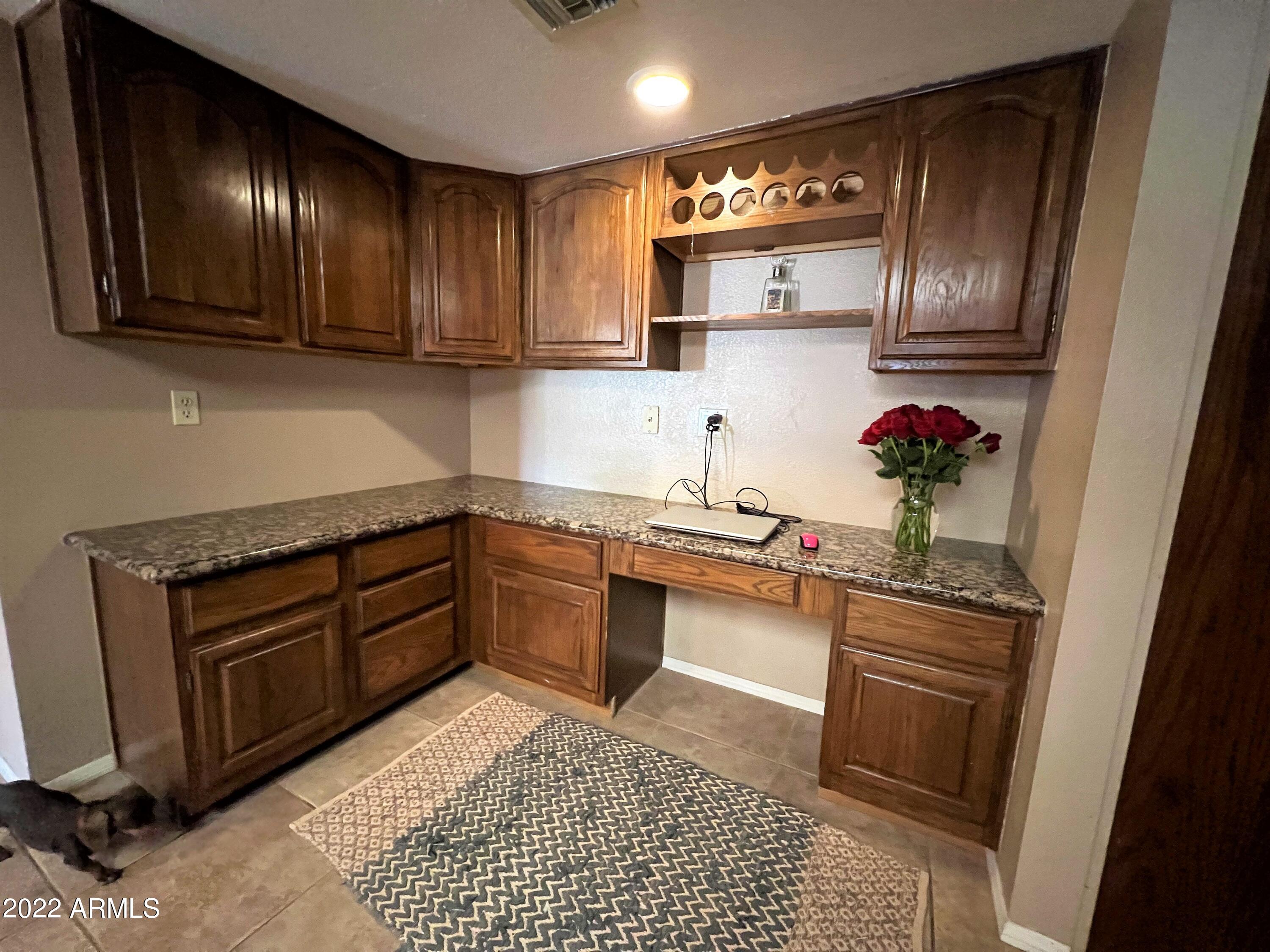 16502 West Magnolia Street Goodyear, AZ 85338 - Photo 18 of 59 a kitchen with stainless steel appliances granite countertop a sink stove and cabinets