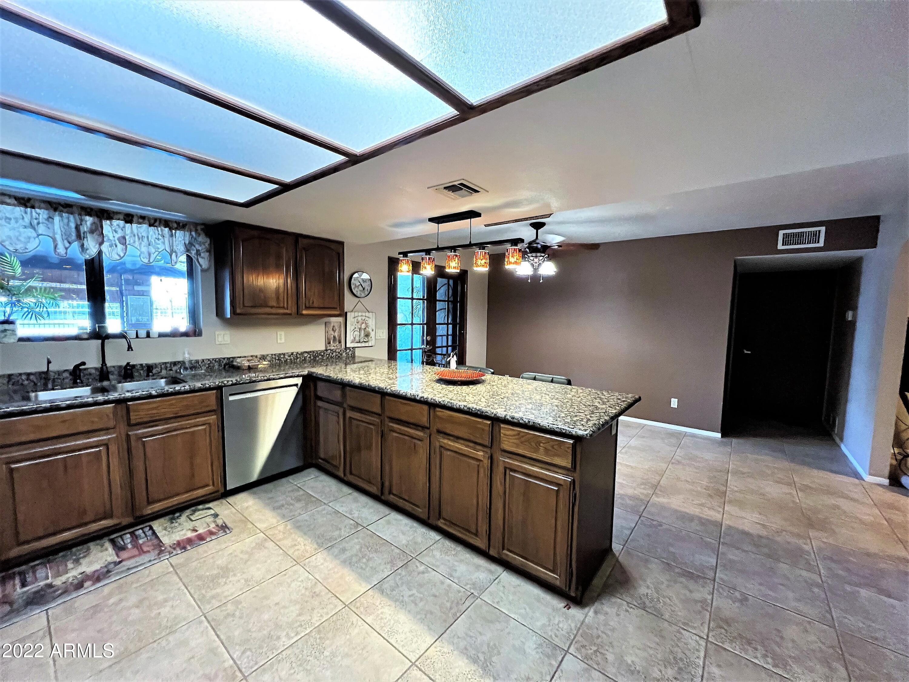 16502 West Magnolia Street Goodyear, AZ 85338 - Photo 19 of 59 a large kitchen with stainless steel appliances granite countertop a sink and cabinets