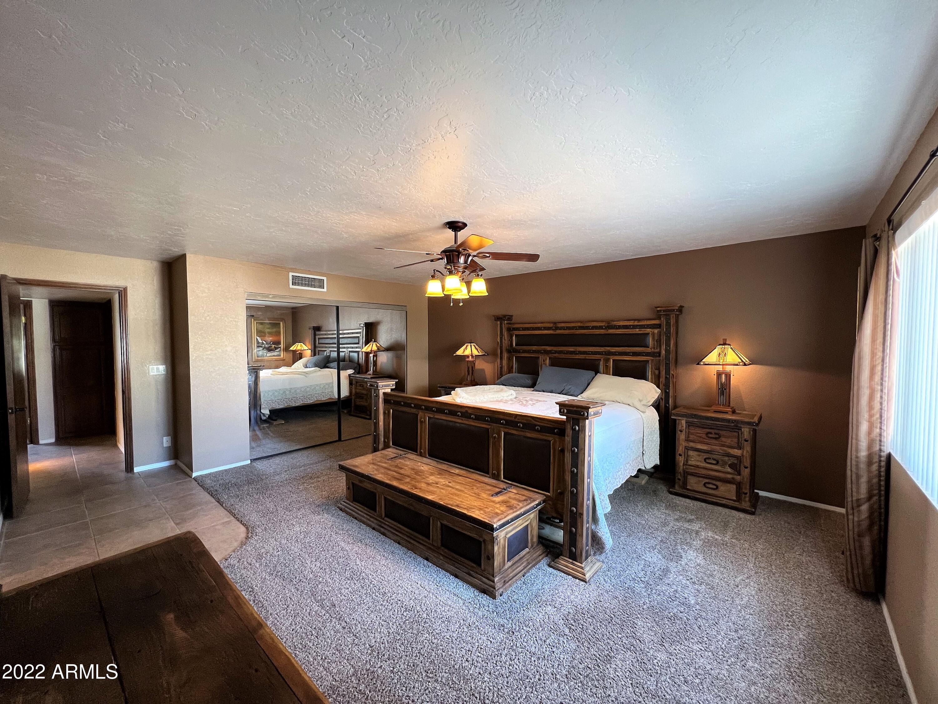 16502 West Magnolia Street Goodyear, AZ 85338 - Photo 23 of 59 a bed room with furniture and a lamp
