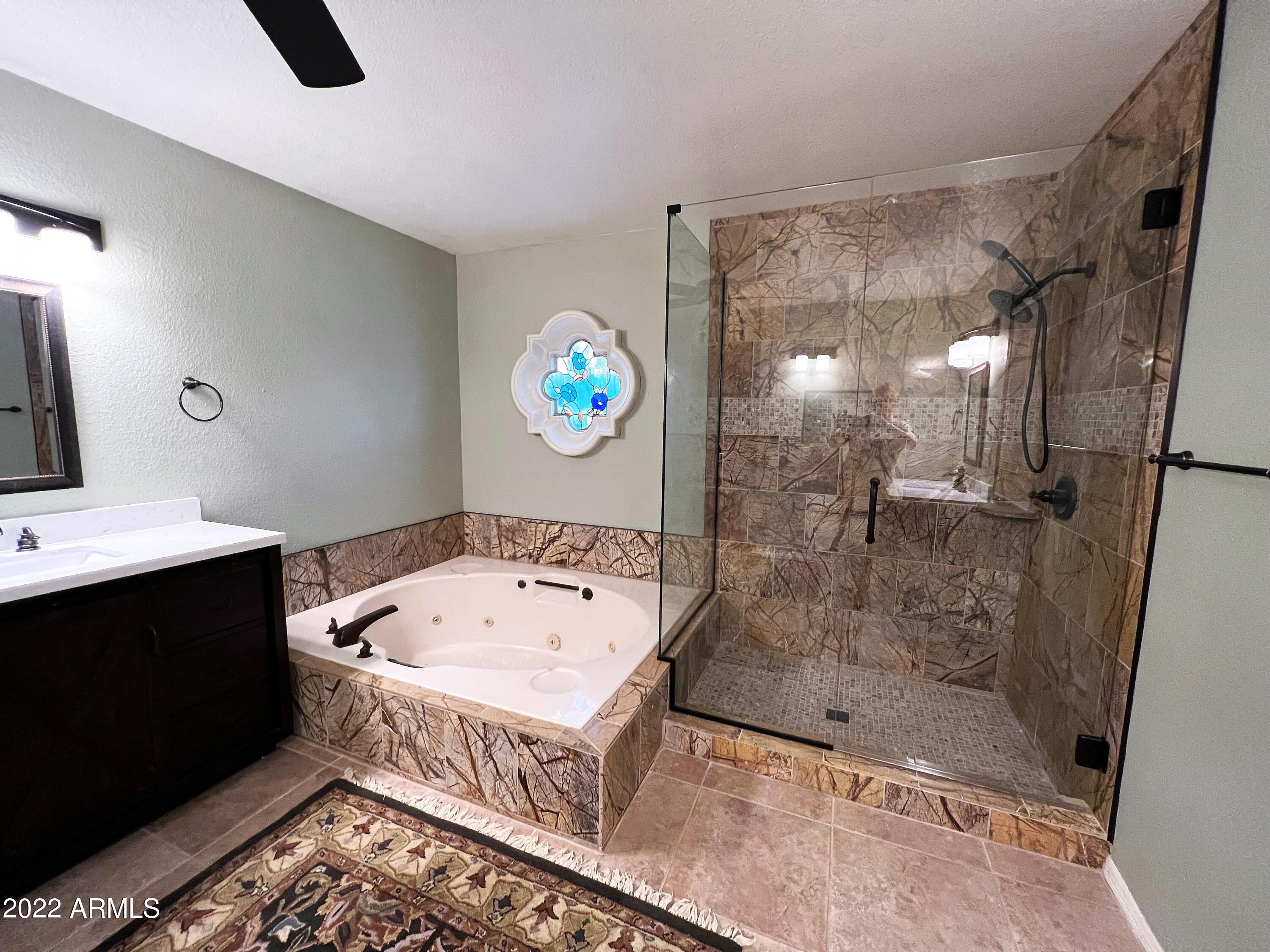 16502 West Magnolia Street Goodyear, AZ 85338 - Photo 25 of 59 a bathroom with a tub a sink and a shower