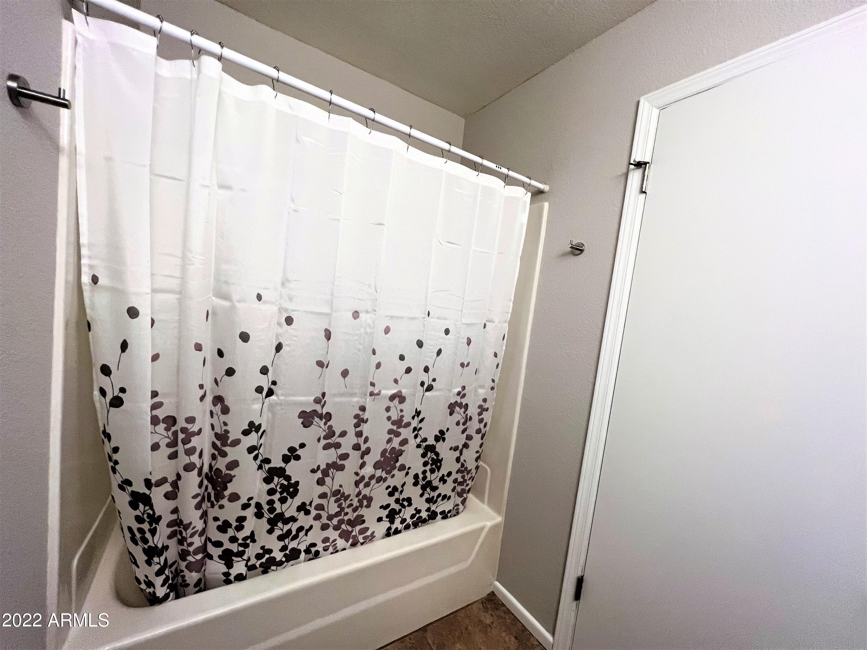 16502 West Magnolia Street Goodyear, AZ 85338 - Photo 32 of 59 a bathroom with a shower curtain and a shower curtain