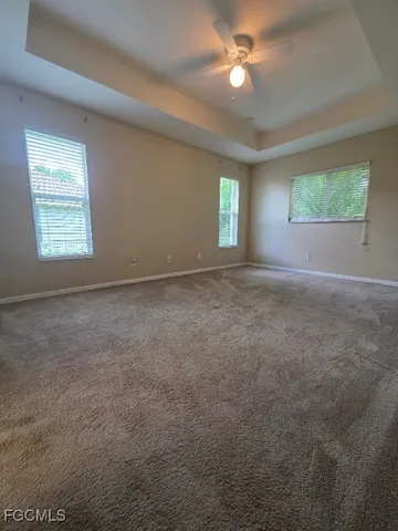 an empty room with a window and ceiling fan