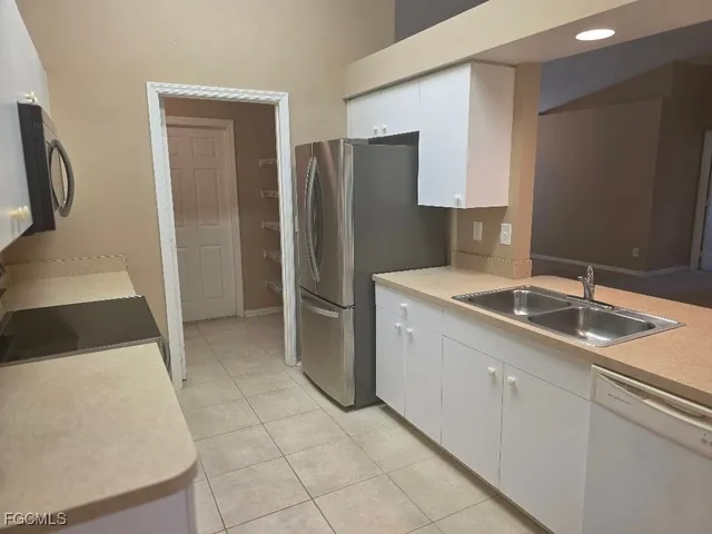 a kitchen that has a sink a refrigerator and a sink