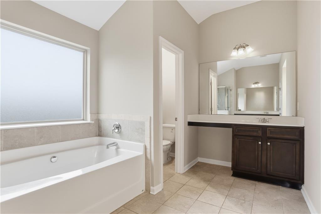 1021 Reddy Farm Lane Grayson, GA 30017 - Photo 20 of 22 a bathroom with a bathtub sink vanity and mirror