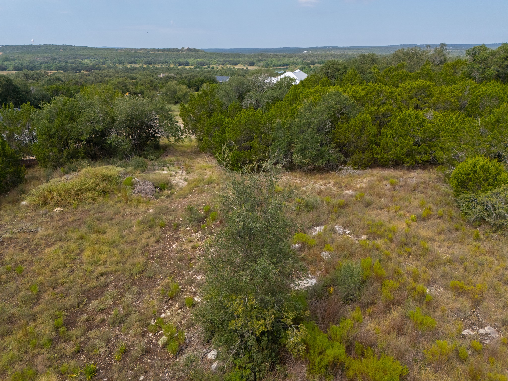 115 Upper River Place Spring Branch, TX 78070 - Photo 13 of 19 A natural hillside landscape features dense native trees and distant panoramic countryside views.